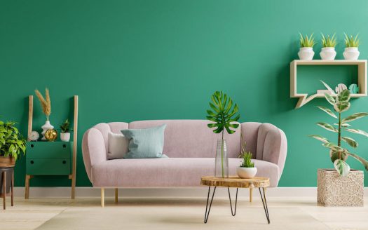 A living room with green walls and a pink couch.